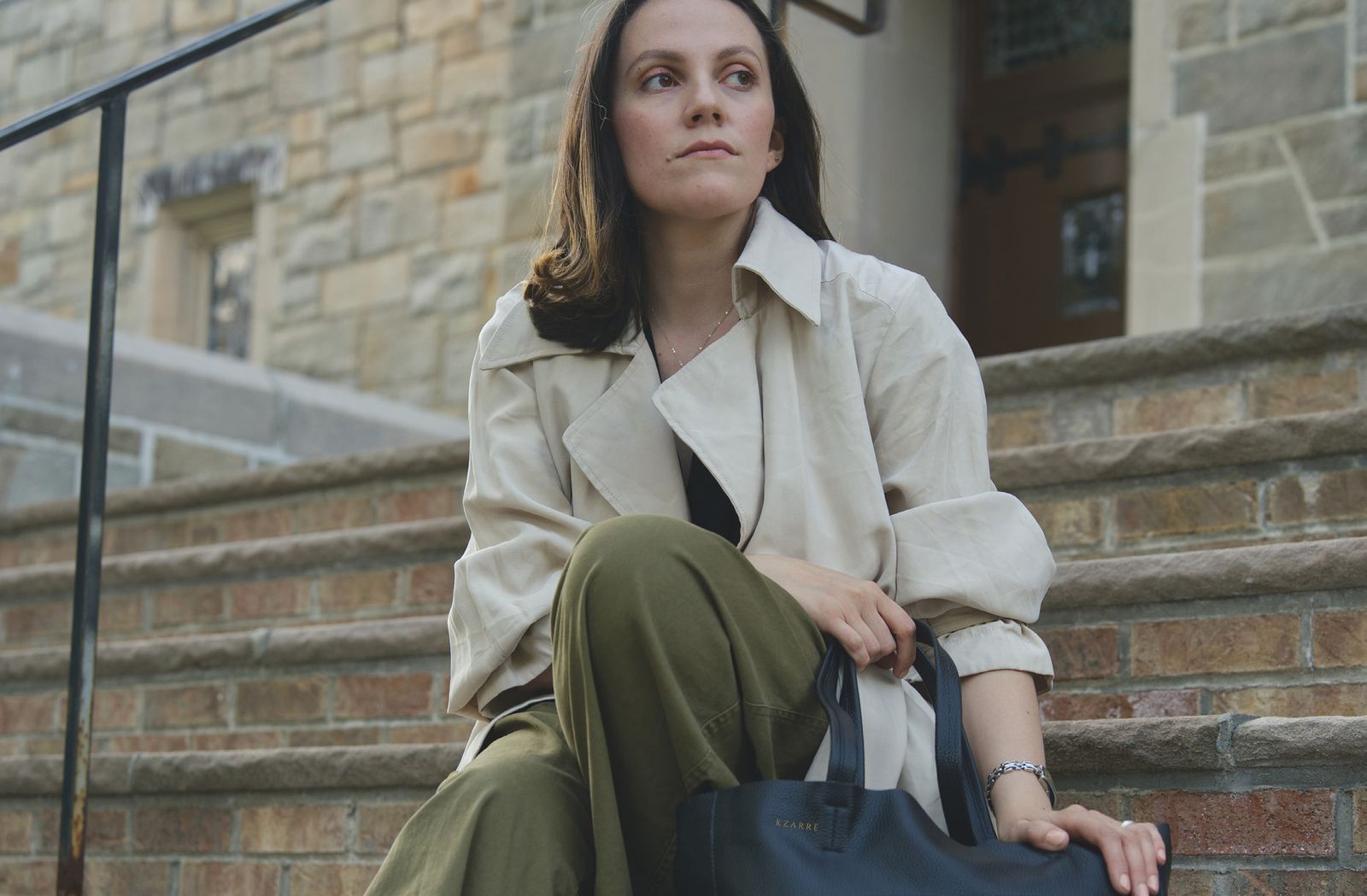 The Essex Tote in noir leather on stone steps